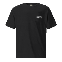 Load image into Gallery viewer, Black colored t shirt with pocket. The pocket says UNFTR in white and the back has has a photo of Milton Friedman with a red circle strikethrough