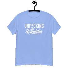 Load image into Gallery viewer, Carolina blue colored classic tee shirt that says Unf*cking The Republic in white on the front and F*ck Milton Friedman in white on the back