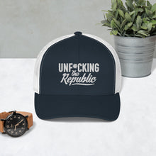 Load image into Gallery viewer, Navy trucker hat with white side panels with white Unf*cking The Republic logo embroidered on the front