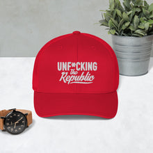 Load image into Gallery viewer, Red trucker hat with red side panels with white Unf*cking The Republic logo embroidered on the front