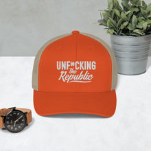 Load image into Gallery viewer, Orange trucker hat with tan side panels with white Unf*cking The Republic logo embroidered on the front