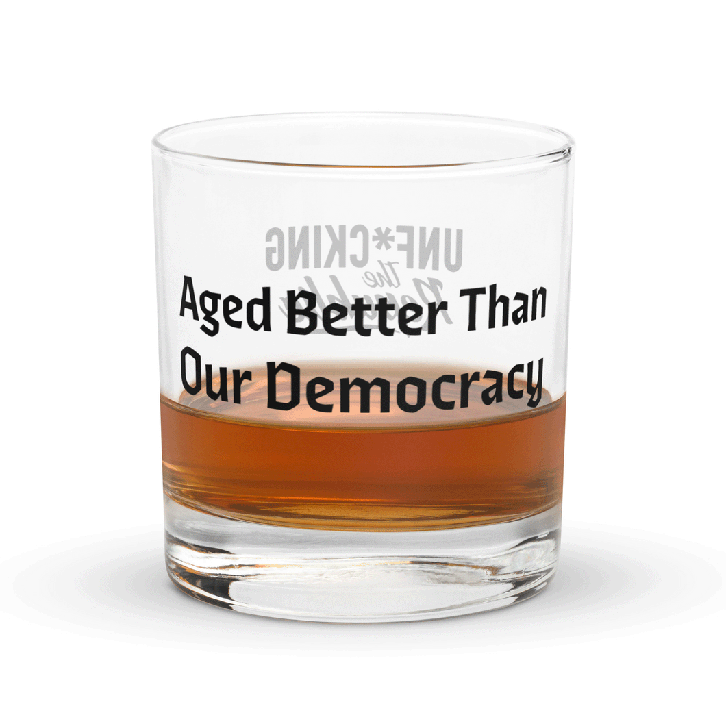 Slightly filled rocks glass with black text that reads Aged Better Than Our Democracy with Unf*cking The Republic logo