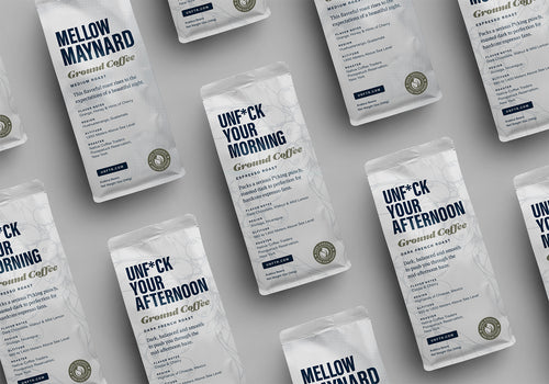 UNFTR Coffee bags laying on a table. The bags featured are Unf*ck Your Morning, Unf*ck Your Afternoon and Mellow Maynard.