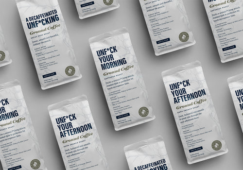 UNFTR Coffee bags laying on a table. The bags featured are Unf*ck Your Morning, Unf*ck Your Afternoon and A Decaffeinated Unf*cking.