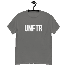 Load image into Gallery viewer, Charcoal gray colored classic tee shirt that says UNFTR in white on the front and Meeting People Where They Are in white on the back
