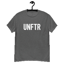 Load image into Gallery viewer, Heather gray colored classic tee shirt that says UNFTR in white on the front and F*ck Milton Friedman in white on the back
