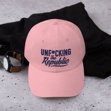 Load image into Gallery viewer, Light pink dad hat with navy embroidered Unf*cking The Republic logo
