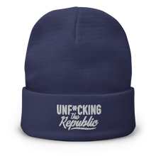 Load image into Gallery viewer, Navy cuffed beanie with white embroidered logo that says ‘Unf*cking The Republic’
