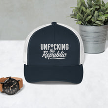 Load image into Gallery viewer, Navy trucker hat with white side panels with white Unf*cking The Republic logo embroidered on the front
