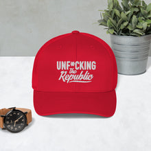 Load image into Gallery viewer, Red trucker hat with red side panels with white Unf*cking The Republic logo embroidered on the front
