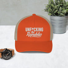 Load image into Gallery viewer, Orange trucker hat with tan side panels with white Unf*cking The Republic logo embroidered on the front
