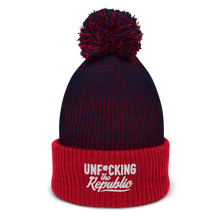 Load image into Gallery viewer, Speckled navy and red pom-pom beanie with white embroidered logo that says ‘Unf*cking The Republic’
