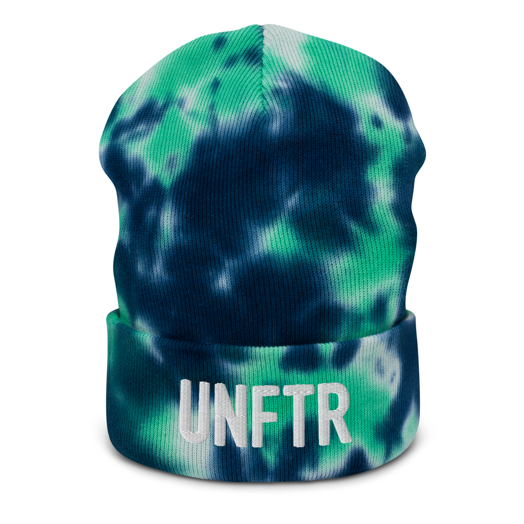 Navy, turquoise and white beanie with embroidered white logo that says ‘UNFTR’