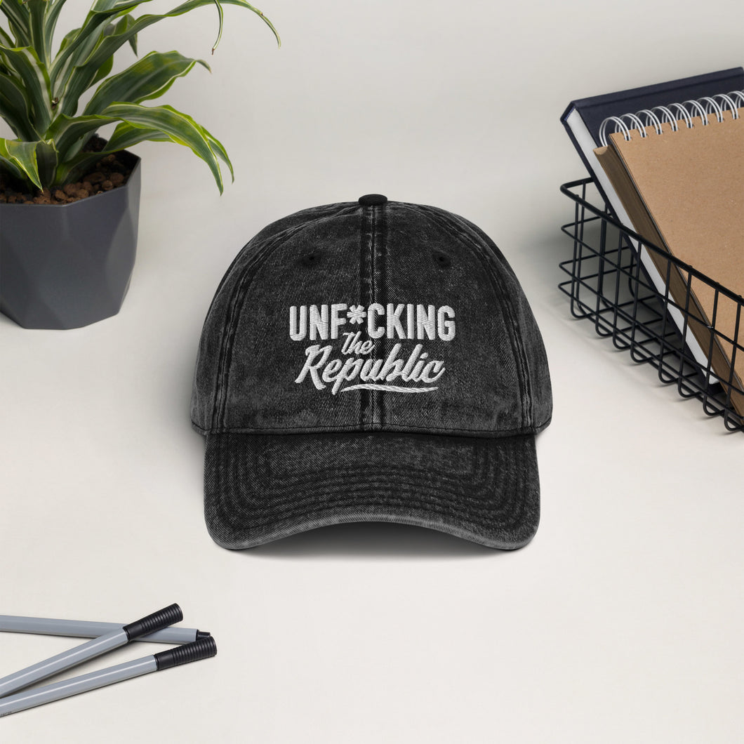 Black/Grey vintage wash dad cap with white Unf*cking The Republic logo embroidered on the front.